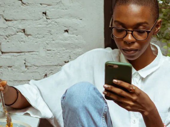 person eating and using a phone