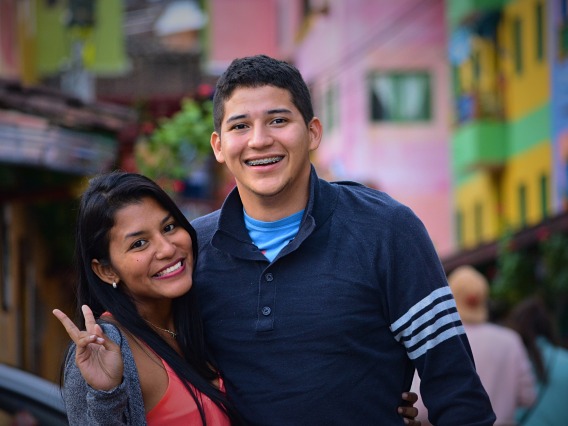 two people smiling and making a peace sign
