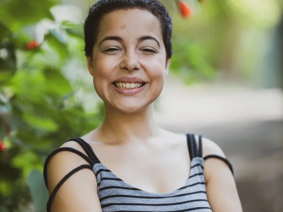 person standing next to a tree and smiling