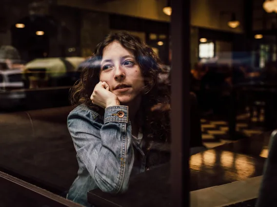 a person resting their head on their hand and looking out the window