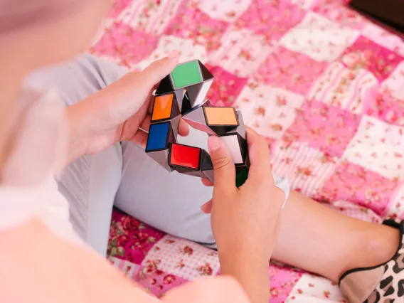 overhead view of someone playing with a 3-dimensional puzzle