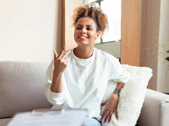 person sitting on a couch talking to someone just outside of the frame