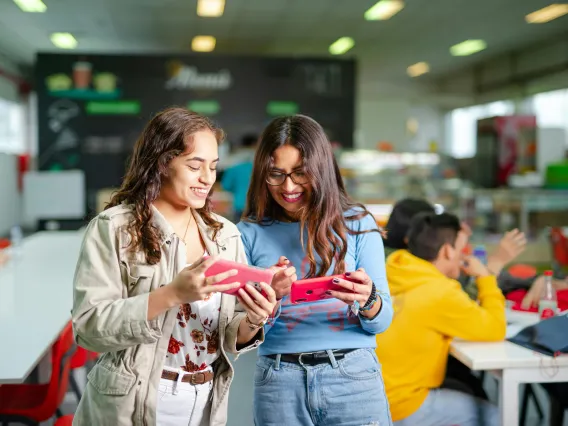 two people looking at phones and smiling