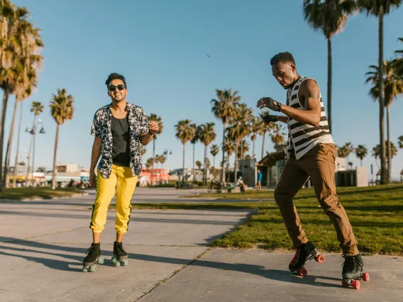 two people roller skating with palm trees visible in the background