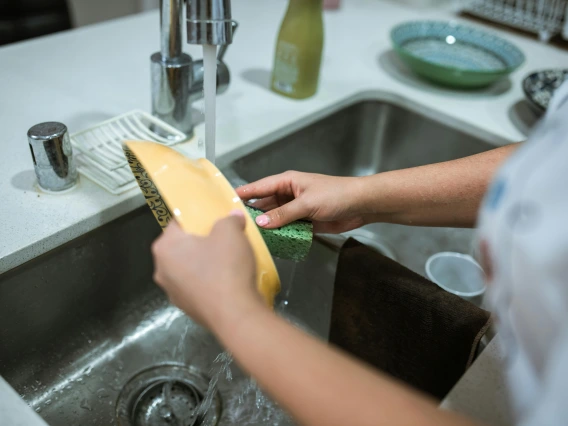 close-up of a person's hands washing dishes