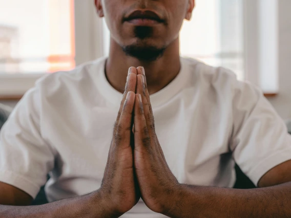 close-up image of a person pressing their hands together