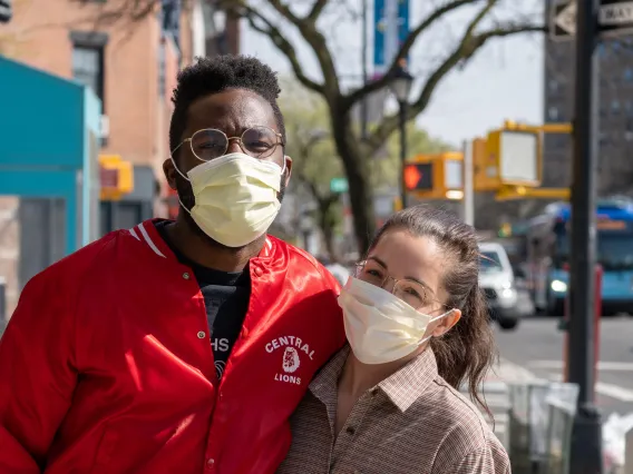 two people wearing masks outside