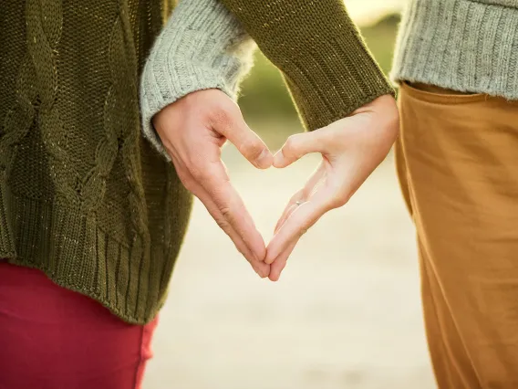 two people holding their hand together in the shape of a heart