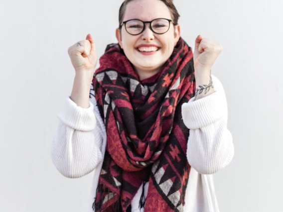 smiling person wearing glasses and a scarf