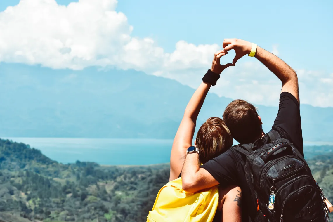 two people viewed from behind hold their hands together in the shape of a heart