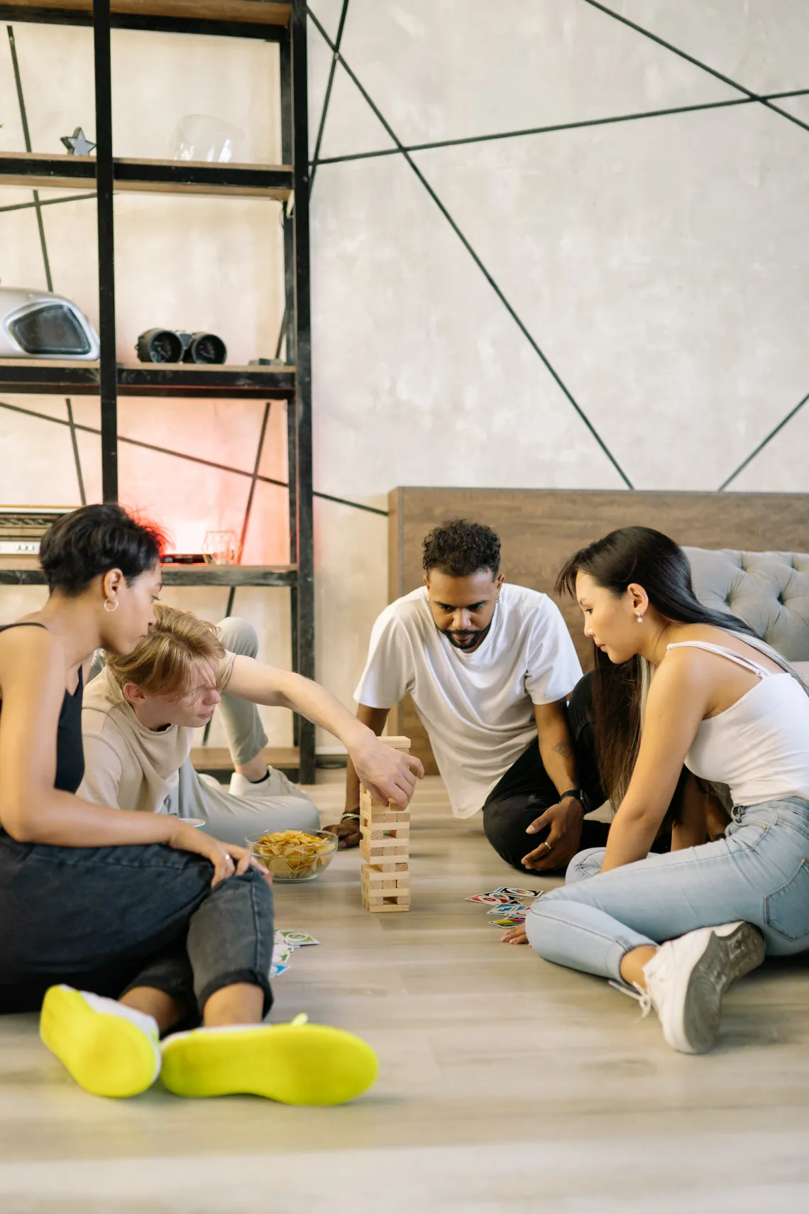 group of friends playing a stacking block game