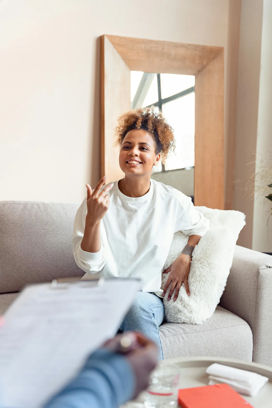 person sitting on a couch talking to someone just outside of the frame