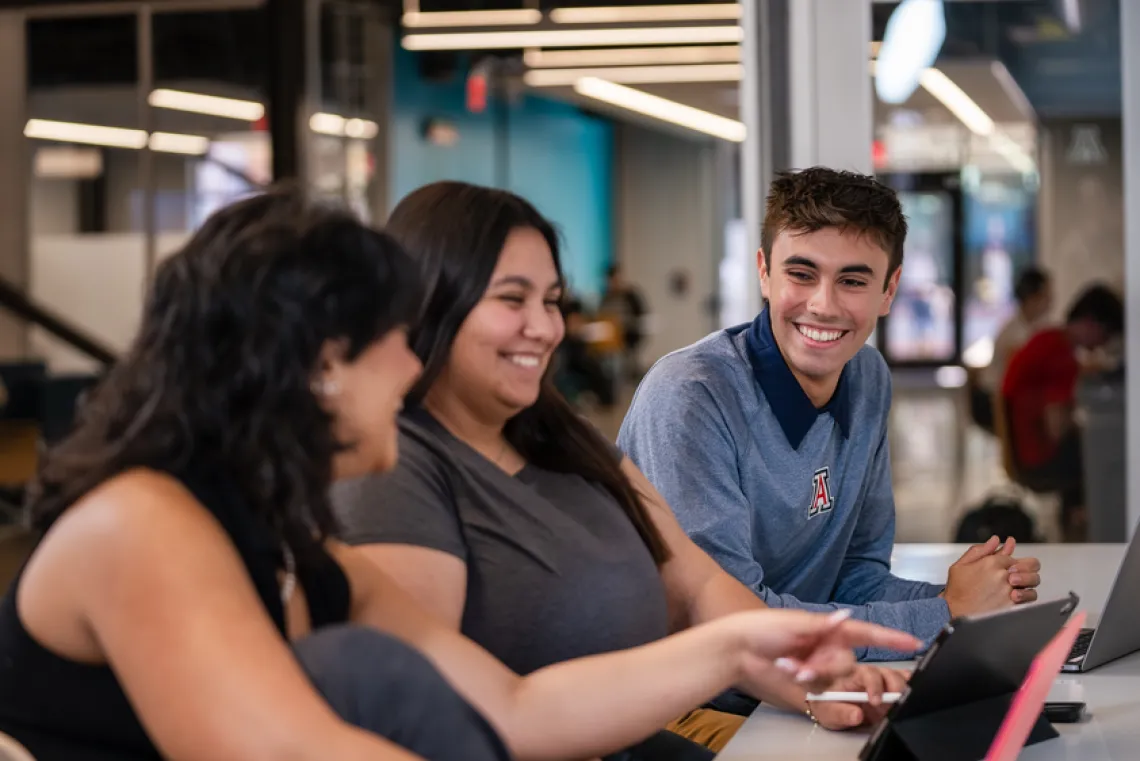 Group of 3 students sitting together and talking