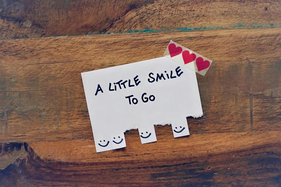 sheet of paper with smiley faces and hearts with text that reads "a little simle to go"