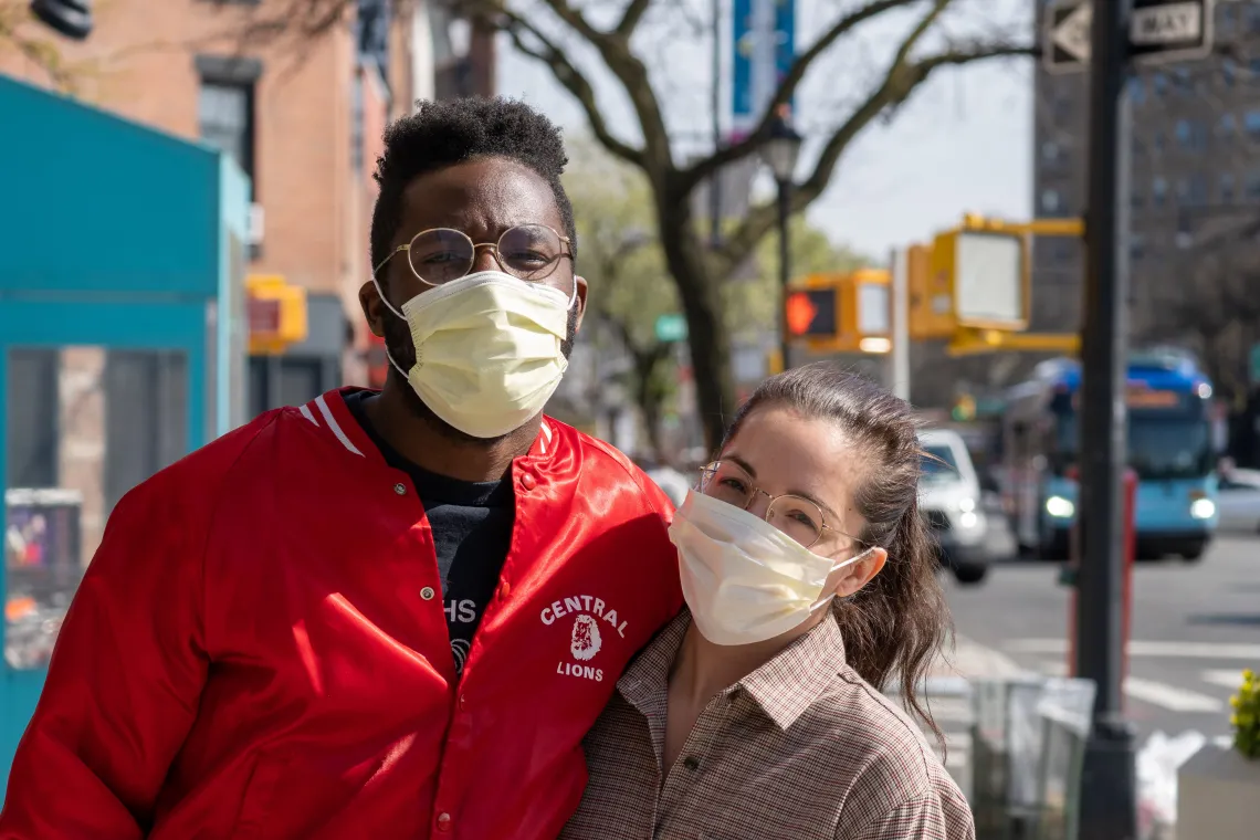 two people wearing masks outside