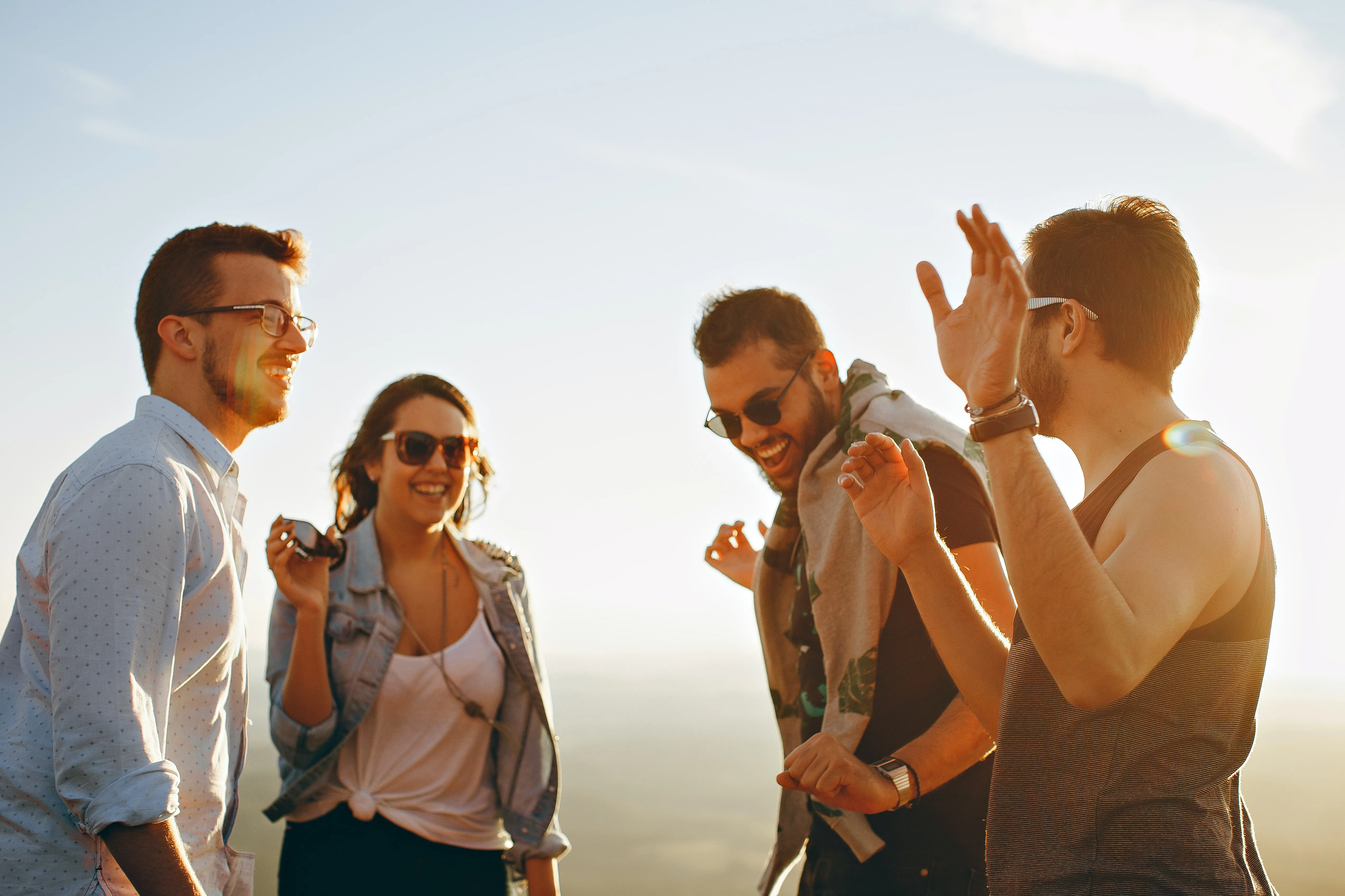 Four people outside laughing together